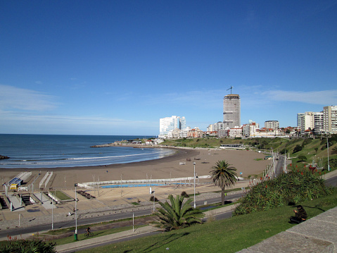 View of the coastal area of the city of Mar del Plata, in Playa Varese. Part of the city that looks at the sea, and also a coastal promenade with landscaped areas and steps in a beautiful sunset of an autumn day, in May 2023.