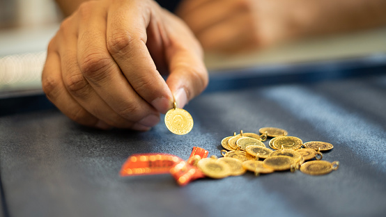 man hand holding 1/4 turkish gold