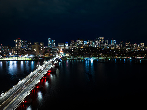 A drone shot of the Boston city skyline at night, seen from Longfellow bridge.
