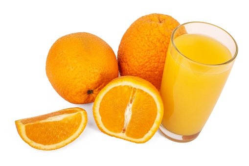 Front view of  a single drinking glass full of orange juice beside a sliced orange isolated on white background