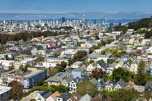 Aerial shot of residential streets in the Outer Sunset Neighborhood of San Francisco, with the financial distrcxt skyline and the bay in the distance.