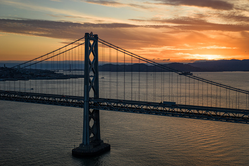 Long exposure photo in Marshall's Beach with Golden Gate Bridge in the background in San Francisco at sunset, California