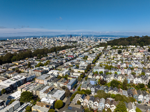 An aerial shot of the Haight-Ashbury neighborhood in San Francisco during the day, with the urban skyline visible in the background.