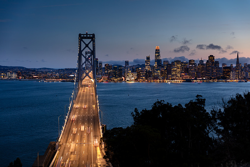 An aerial view of the San Francisco skyline seen from the San Francisco-Oakland Bay Bridge at dusk.