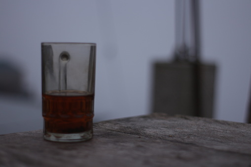 Glass of hot tea against a background of thick fog on a dry summer day.