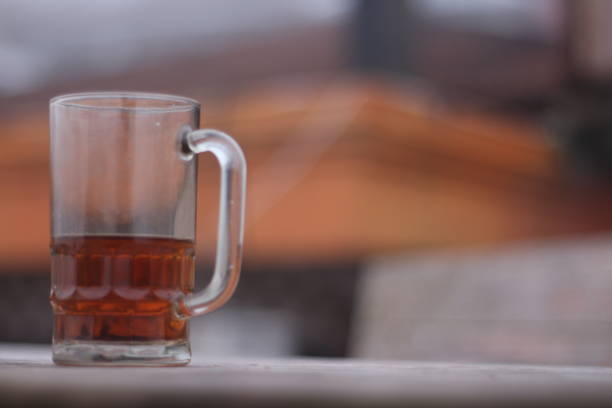 Glass of hot tea against a background of thick fog on a dry summer day.