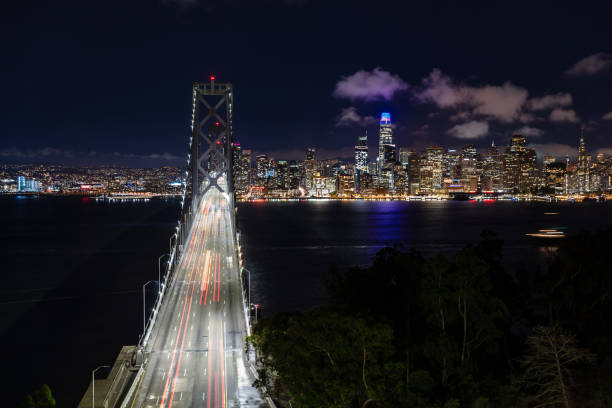An aerial view of the San Francisco skyline seen from the San Francisco-Oakland Bay Bridge at night.