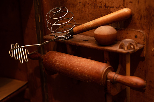 Old wooden kitchen tools, rolling pin, dough whisk, wooden ball for whipping dough. Rustic kitchen.Close-up.