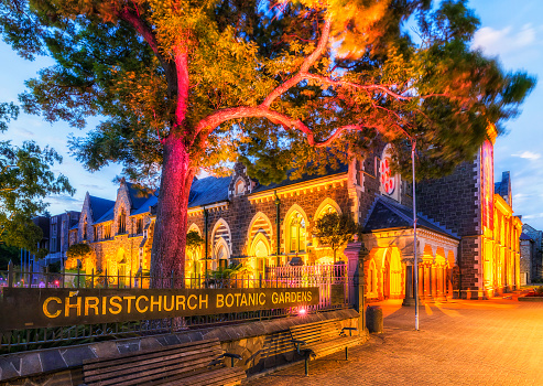 Public Christchurch botanic gardens entrance gate at sunset with bright illumination in historic downtown district of the city.