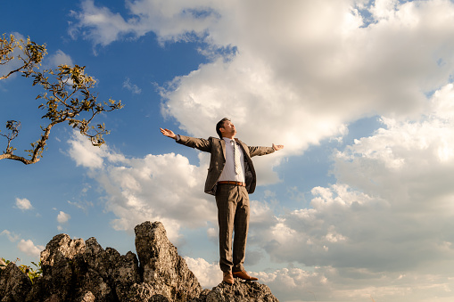 Relaxing businessman standing on the mountain, Thailand