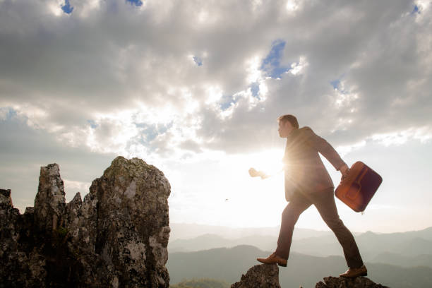 istock Businessman jumps over a cliff between two mountains. Ideas about commitment, business, challenges, success, risks, etc. 1499073614