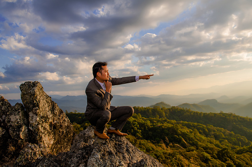 Businessmen stand on high peaks and look to the foreground landscape, conceptual leader.