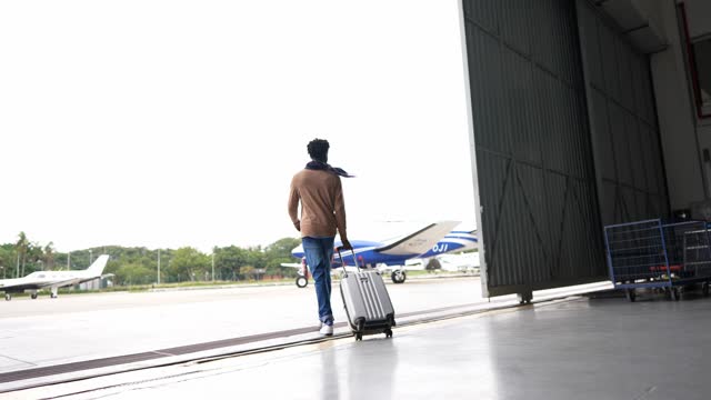 Young man walking while carry a suitcase in the airport