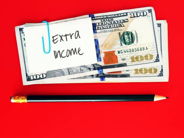 istock Dollars cash money and pencil on red copy space background with note written EXTRA INCOME , concept of full time employees increase earnings boost more income from part time , side jb , side hustle or side gig 1499089738