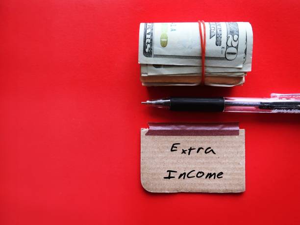 istock On copy space red background, cash dollars money with pen writing on note EXTRA INCOME, concept of make more income from side business or second job along to boost extra cash 1499100611