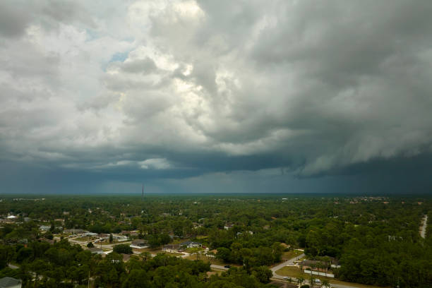istock Dark stormy clouds forming on gloomy sky before heavy rainfall over suburban town area 1499102706