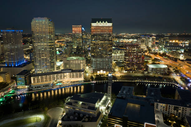 vista de cima de edifícios de arranha-céus altos brilhantemente iluminados no centro da cidade de tampa, na flórida, eua. megapole americana com distrito financeiro de negócios à noite - new york state skyline new york city vibrant color - fotografias e filmes do acervo