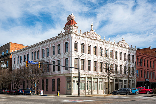 Montgomery, Alabama, USA-Feb. 7, 2023: The historic Steiner-Lobman Building built in 1891 in Montgomery's downtown entertainment district. It features a statue of the goddess Athena, an anvil and a casket perched atop.