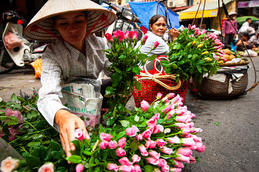 A florist peddling her goods on the streets of Hanoi.
