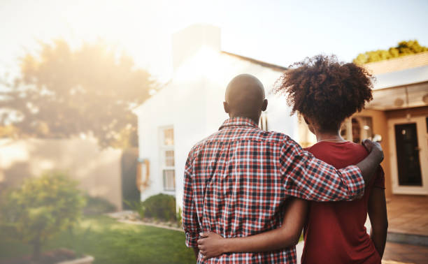 Back view, black couple and hug outdoor at house, real estate and new loan for luxury home. Man, woman and people in front of property investment, moving and dream neighborhood for building mortgage What a lovely place to call our home mover stock pictures, royalty-free photos & images