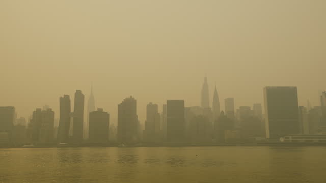 Tilt Up From East River In NYC To Manhattan Skyline Under Unusually Heavy Haze