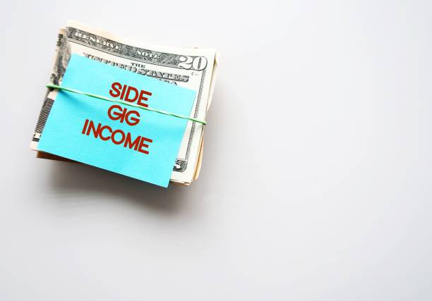 istock On white copy space background, dollars cash money with text note SIDE GIG INCOME, concept of financial planning - make more money or extra earning from part time side hustle , second job or side gig to increase income 1499112063