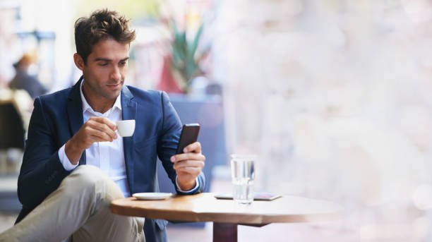 Businessman, coffee shop and phone for networking with mockup space, reading and focus at table. Man, smartphone and espresso with communication, social media app and texting on web chat ux at cafe