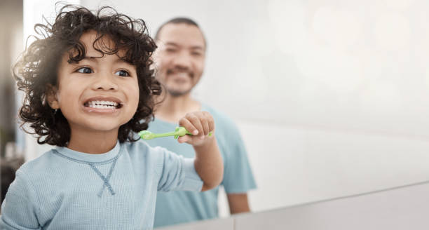 istock Brushing teeth, kid and boy with dental hygiene with father as child development in the bathroom for health and care. Young, mockup and toddler cleaning his oral or mouth in the mirror with dad 1499112113