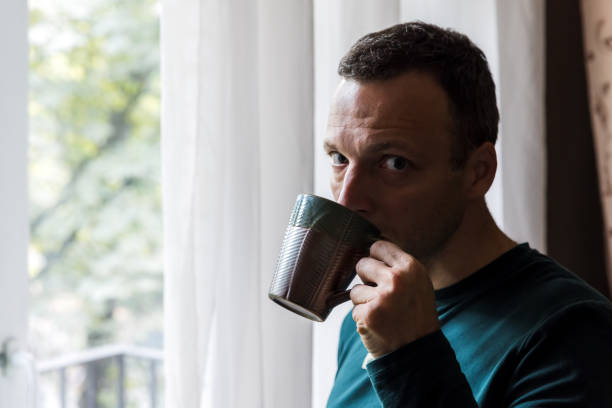 istock Young adult Caucasian man drinks coffee 1499115733