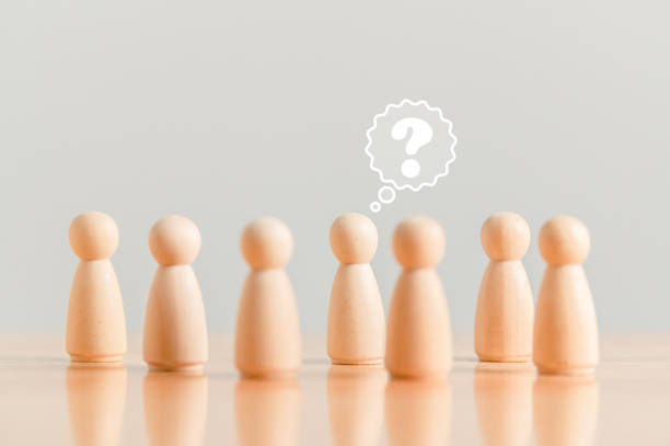 istock Wooden figurine as person who have questions and need help solving the problems among crowd people. Man has no idea on wood table. Business marketing and Creative solution concept. 1499120378