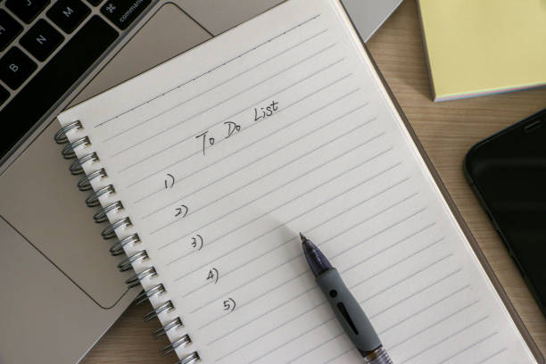 konsep organization and to do list, tempat kerja dengan notepad, bolpoin, beberapa catatan tempel, laptop dan smartphone, di atas meja kayu. daftar periksa untuk pekerjaan dan kehidupan. - to do list potret stok, foto, & gambar bebas royalti