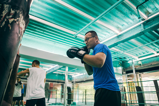 Two Asian boxing enthusiasts are engaged in self-training, dedicating themselves to improving their skills and physical fitness.