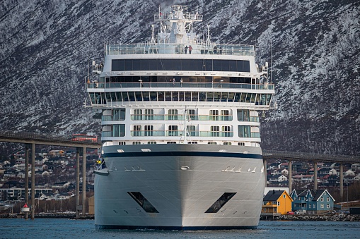 Tromso, Norway – February 20, 2023: A majestic Viking Venus cruise ship docked in the port of Tromso, against snow-capped mountains