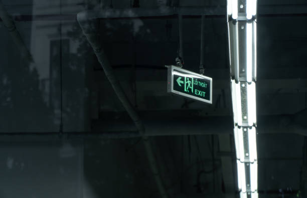 istock Green luminescent exit sign in a service workshop with white light and ceiling background. 1499133426