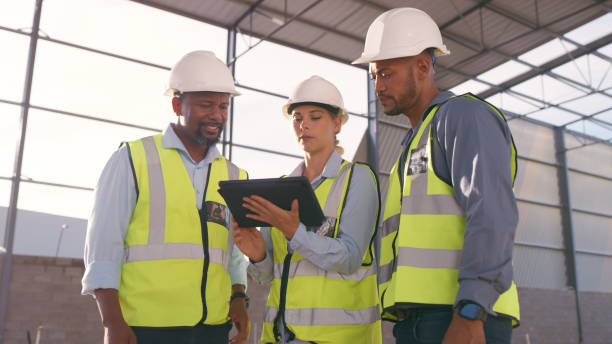 istock People, architect and tablet in construction planning, meeting or collaboration on site. Group of engineer, builder or contractors on technology for team project or industrial architecture 1499135647