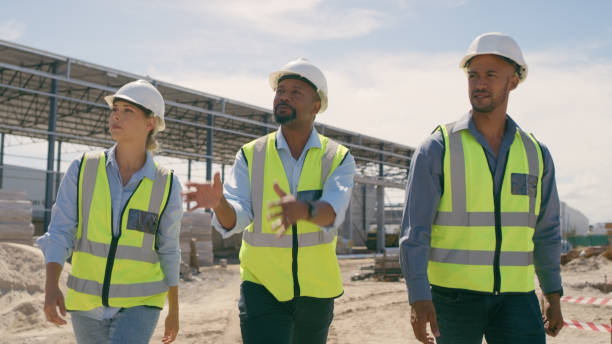 istock People, architect and walking in construction site for planning, collaboration or teamwork. Engineer, builder or contractors discussing team project plan for industrial building architecture 1499135699
