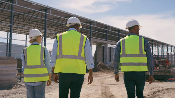 istock People, architect and walking in construction site for planning, collaboration or teamwork. Engineer, builder or contractors discussing team project plan for industrial building architecture 1499135700