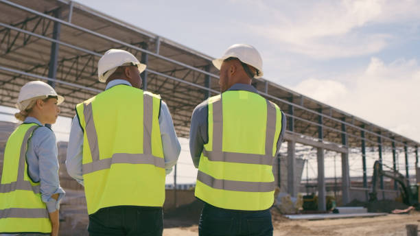 istock People, architect and walking in construction site for planning, collaboration or teamwork. Engineer, builder or contractors discussing team project plan for industrial building architecture 1499135706
