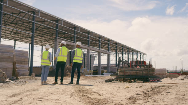 istock People, architect and walking in construction site for planning, collaboration or teamwork. Engineer, builder or contractors discussing team project plan for industrial building architecture 1499135707