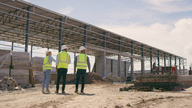 istock People, architect and walking in construction site for planning, collaboration or teamwork. Engineer, builder or contractors discussing team project plan for industrial building architecture 1499135709