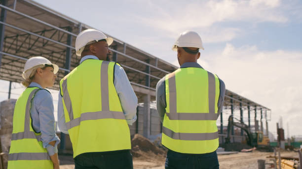 istock People, architect and walking in construction site for planning, collaboration or teamwork. Engineer, builder or contractors discussing team project plan for industrial building architecture 1499135711
