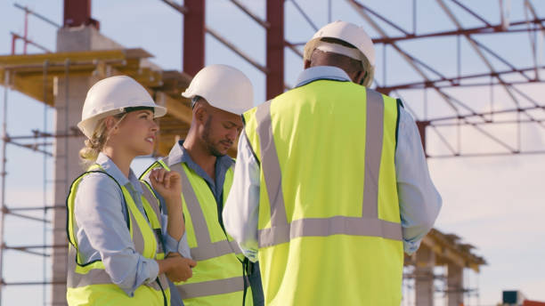 Building, team collaboration and construction site outdoor for architecture and vision talk. Diversity men and woman engineer walking and planning project, engineering and infrastructure development