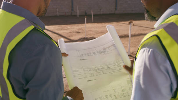 istock Architecture people, blueprint and outdoor planning, teamwork or collaboration at construction site. Engineering project, floor plan and contractor or partner in building development 1499135882