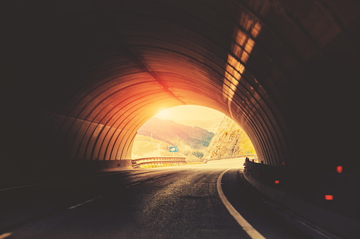 End of the tunnel. Exit from the tunnel. Driving a car on a mountain road