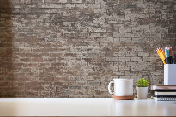 istock Minimal workspace with book, coffee cup and pencil holder on white table. Copy space for your advertising text. 1499140539