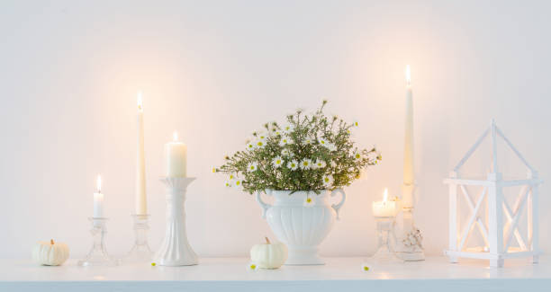 istock white flowers in white ceramic vase with burning candles in white interior 1499146666