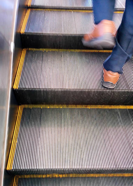 istock Male feet walking up the escalator 1499155085