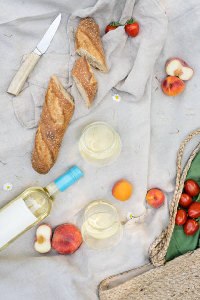 istock Two glasses of white wine and fresh fruit on a picnic blanket. 1499158146