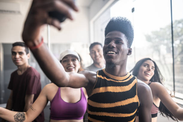 Young man taking selfies using mobile phone in a dancing class at a dance studio