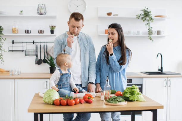 istock Spouses eating cucumber while daughter sitting on table top 1499160393